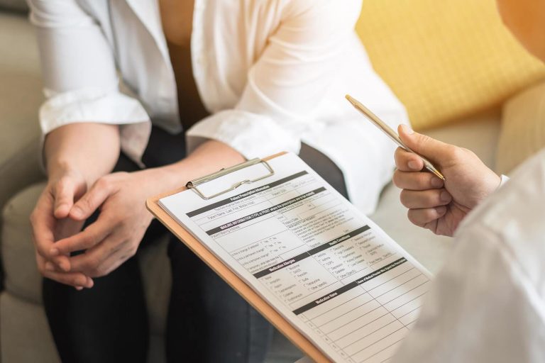 doctor filling out a form with a patient